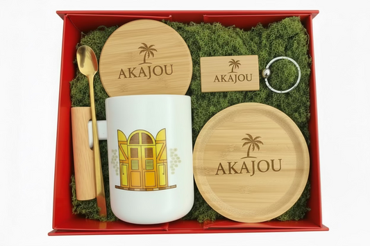 Gift set with mug, wooden coasters, keychain, and spoon in a red box on green moss.